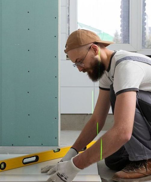 A man is measuring a tile floor with a tape measure.