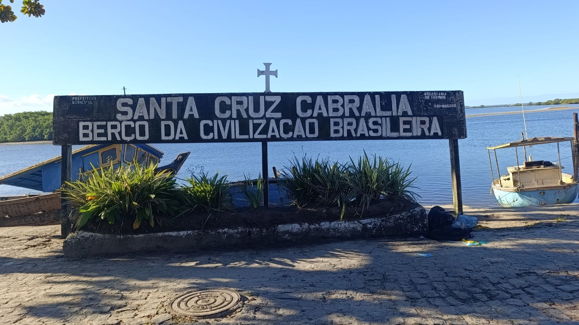 Sign reading “Santa Cruz Cabrália, berço da civilização brasileira” by the waterfront