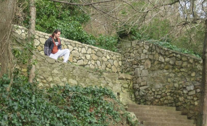 A bewildered man looks upon the natural stone architecture as it has stood for centuries and wonders, will he ever be talented enough to craft such a wall himself.