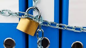 Blue door secured with a chain and gold padlock