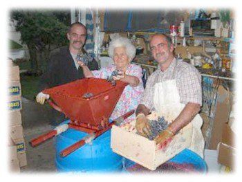older woman and two men in the kitchen preparing meals smiling at the camera