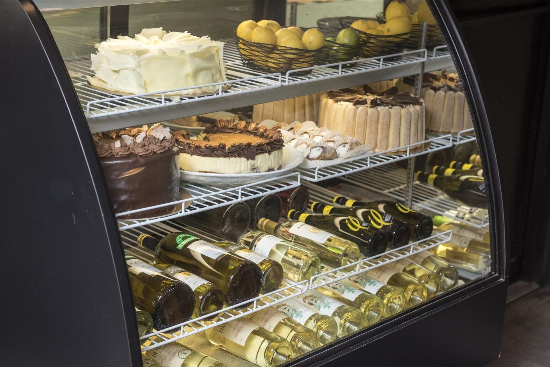 Assortment of Desserts and Wine stored in a fridge
