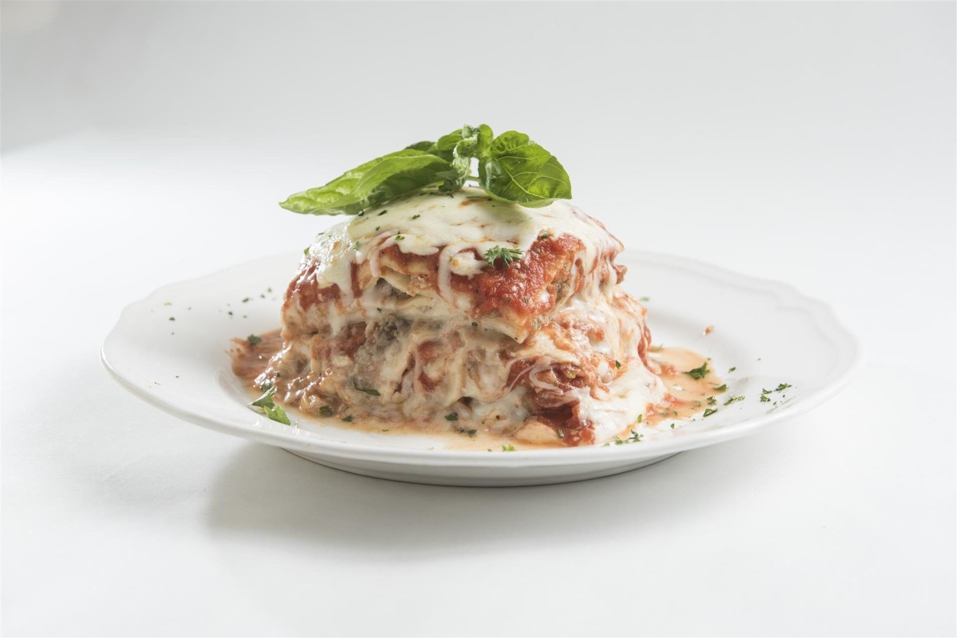 Lasagna topped with fresh basil on a plate