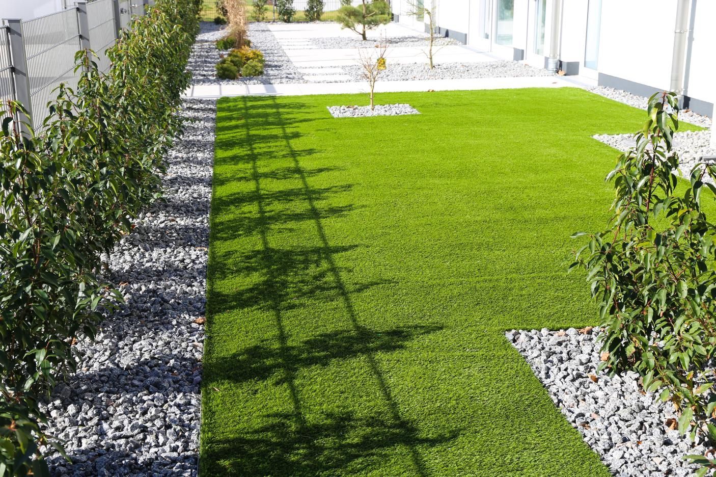 A lush green lawn with a tree in the middle of it.