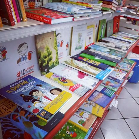 Uno scaffale pieno di libri per bambini, tra cui uno con la scritta #10
