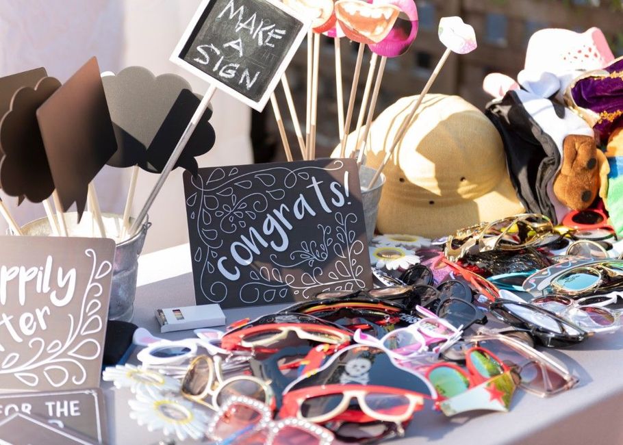 Graduation display with sunglasses, signs, hats, and colorful accessories on a table