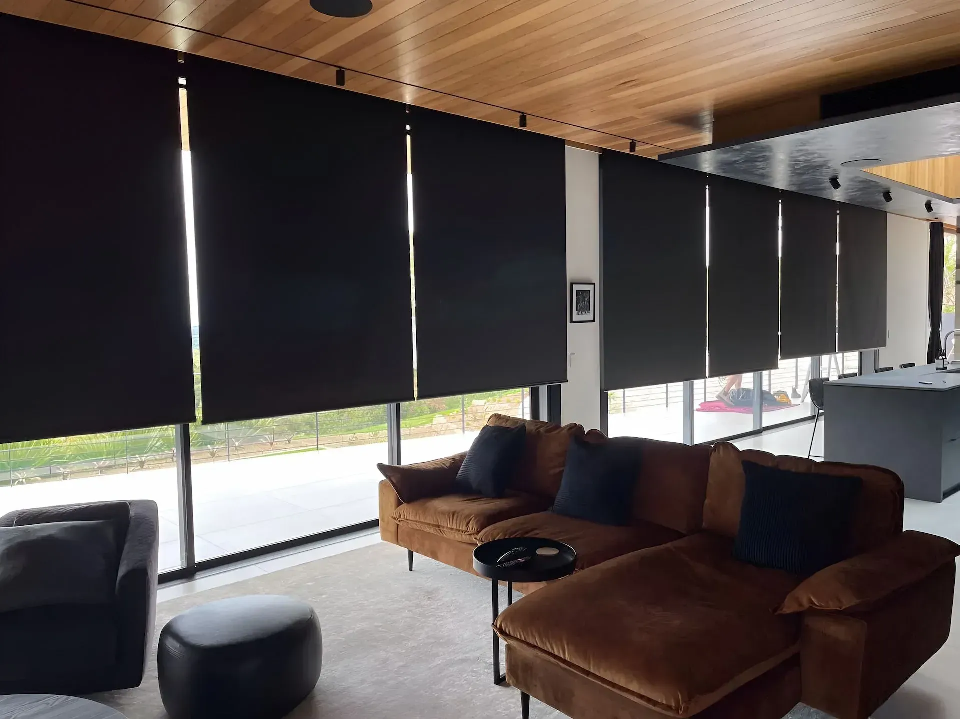 Living Room With Black Roller Shades, Brown Sectional Sofa, and a Wooden Ceiling — BlindDESIGN in Lismore, NSW