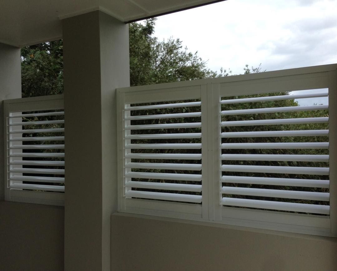 White Shutters on A Balcony Overlooking Trees Under a Cloudy Sky — BlindDESIGN in Byron Bay, NSW
