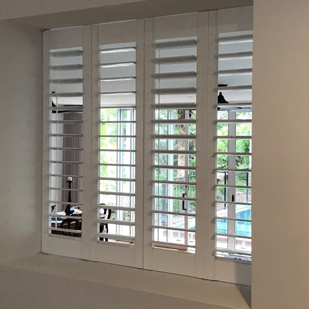 White Shuttered Window With View of Trees and a Pool — BlindDESIGN in Mullumbimby, NSW