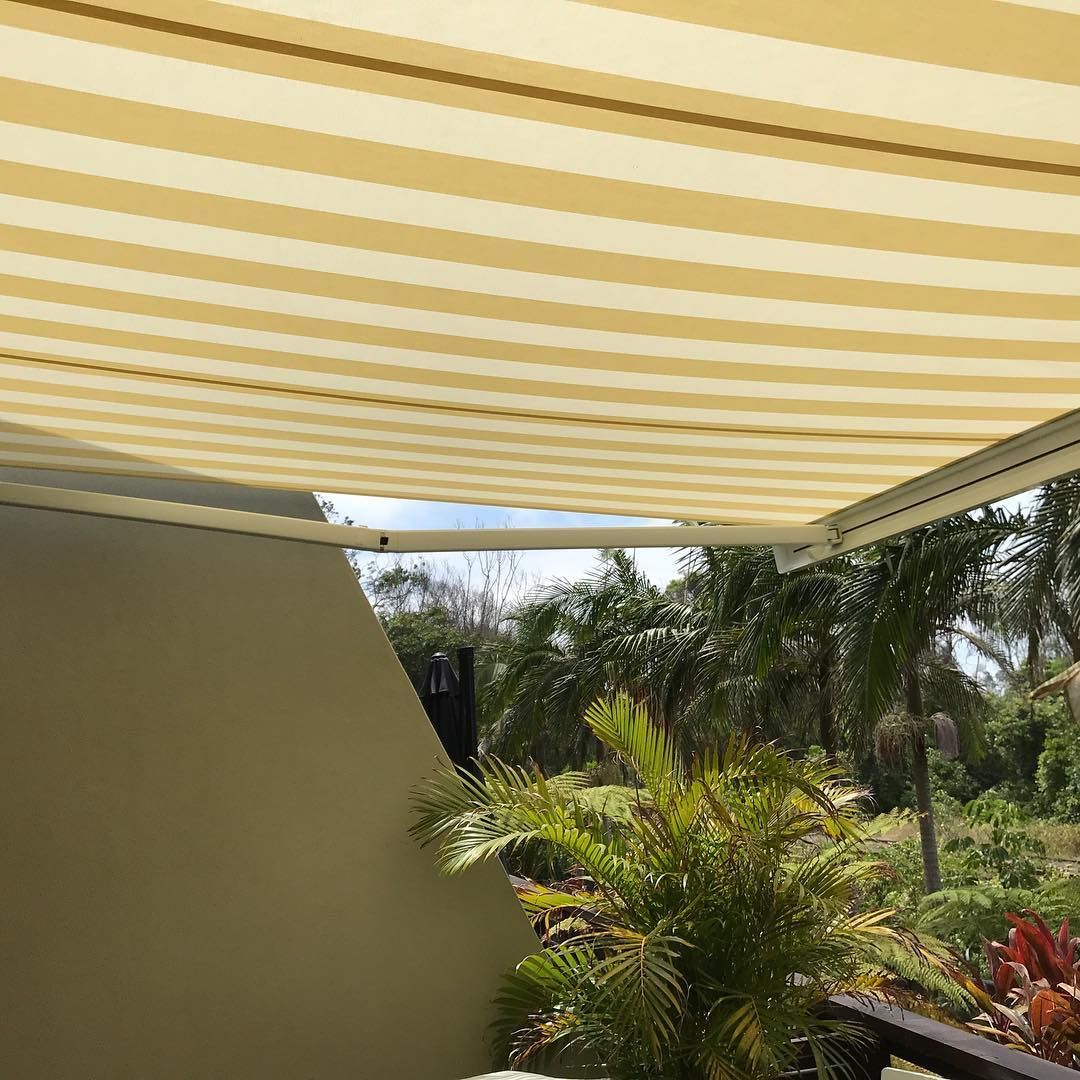 Beige and Yellow Striped Awning Over a Patio, With Trees Visible in the Background — BlindDESIGN in Byron Bay, NSW