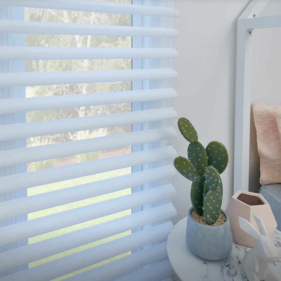 White Zebra Blinds in a Window, Beside a Cactus, With a White Nightstand and a Pink Pillow — BlindDESIGN in Lismore, NSW