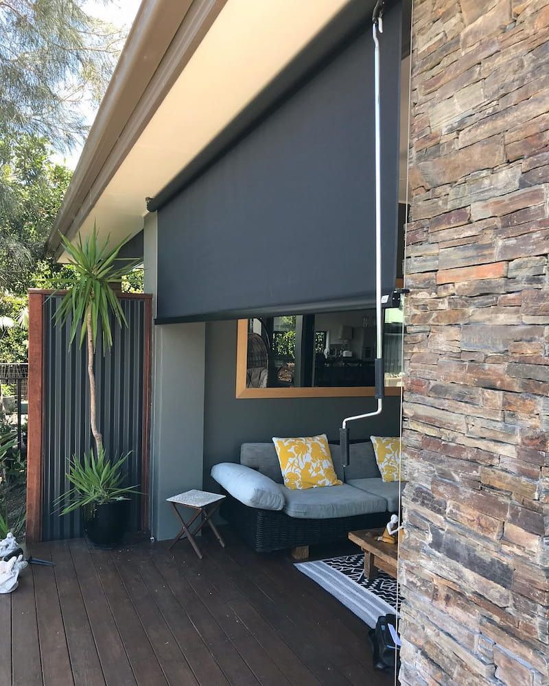 Outdoor Patio With a Retractable Black Sunshade Over a Seating Area — BlindDESIGN in Tweed Heads, NSW