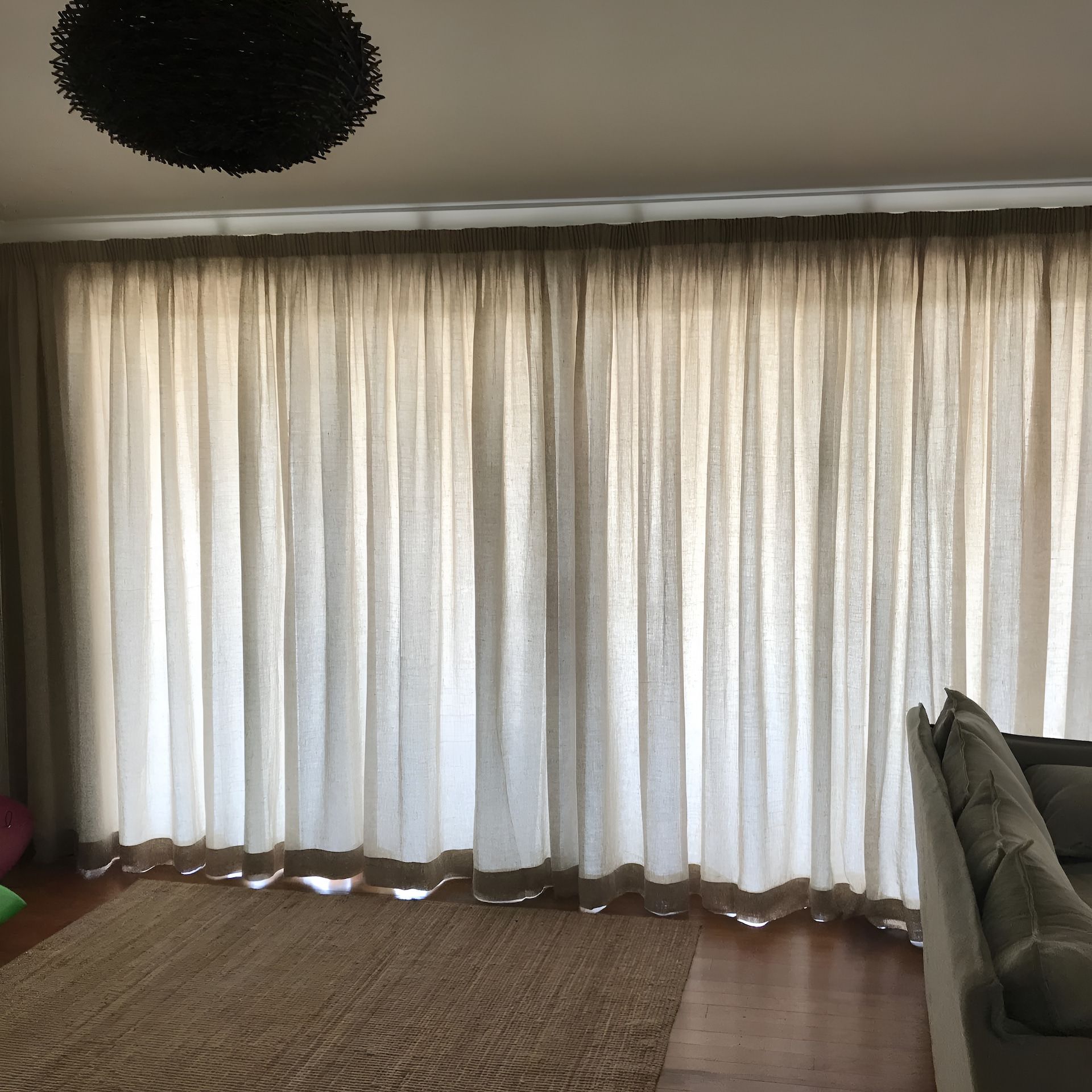 Beige Curtains Draped Over a Window, a Brown Rug on The Floor — BlindDESIGN in Lismore, NSW