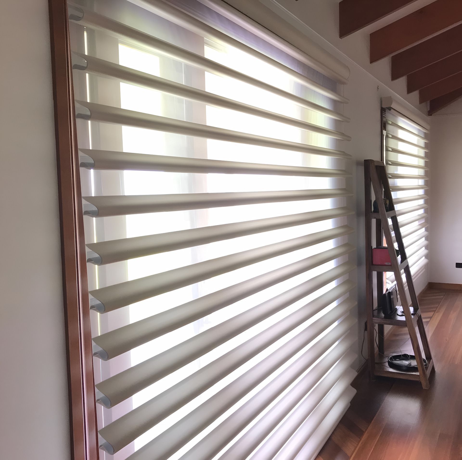 Beige and White Layered Window Blinds in a Bright Room With Wooden Floors — BlindDESIGN in Ballina, NSW