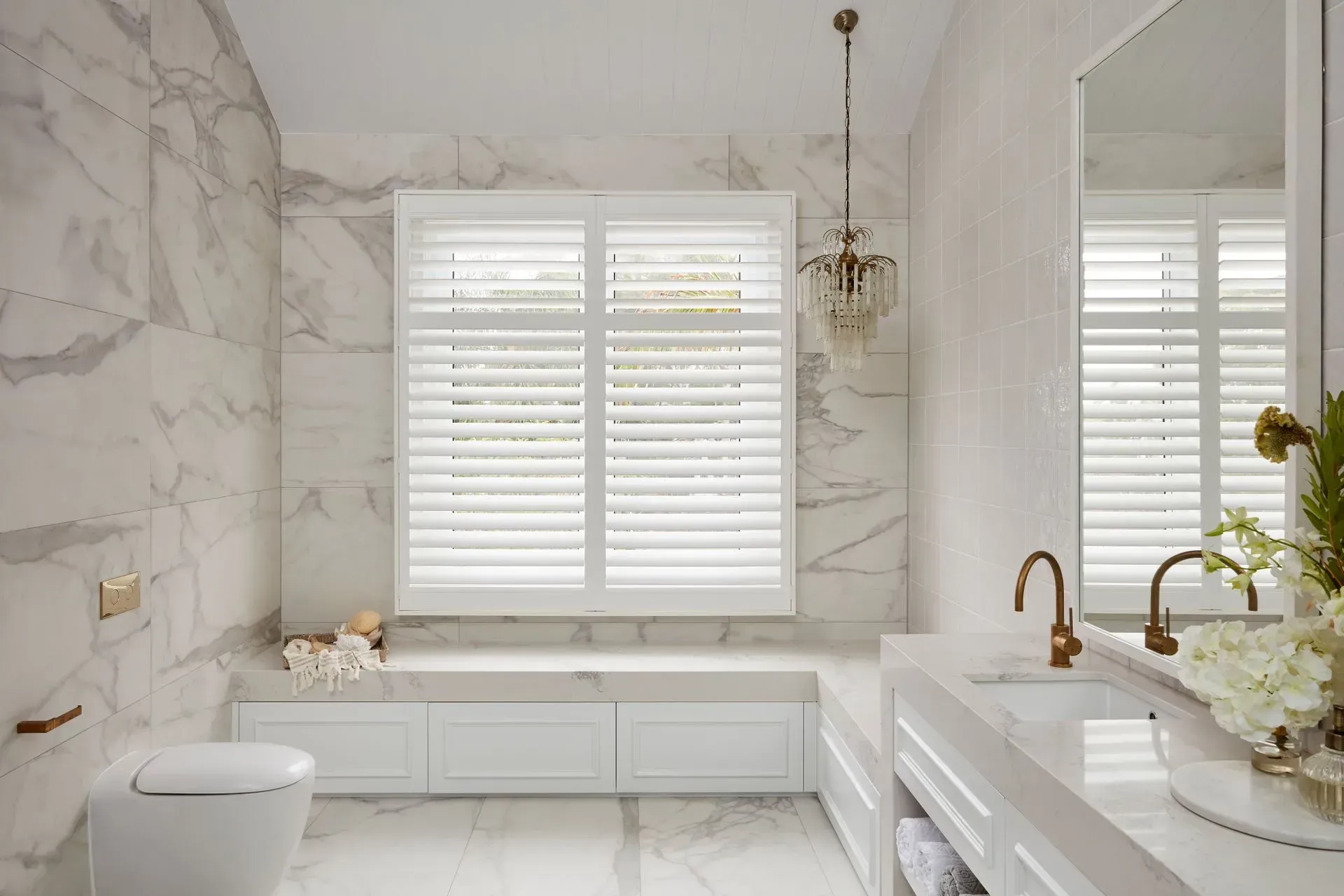 Luxurious Bathroom With Marble Walls, White Shutters, a Toilet, and a Sink — BlindDESIGN in Mullumbimby, NSW