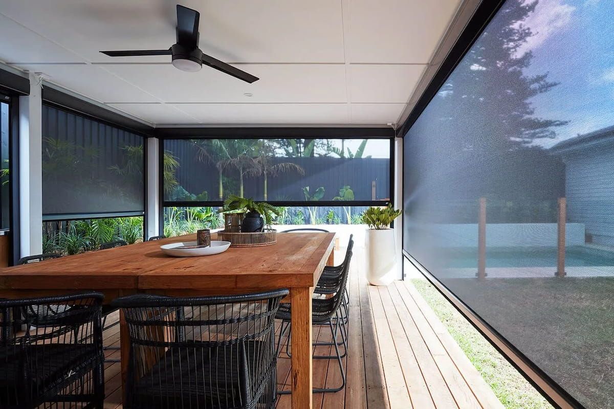 Patio With Wooden Table, Black Chairs, and Roll-down Black Shades — BlindDESIGN in Tweed Heads, NSW