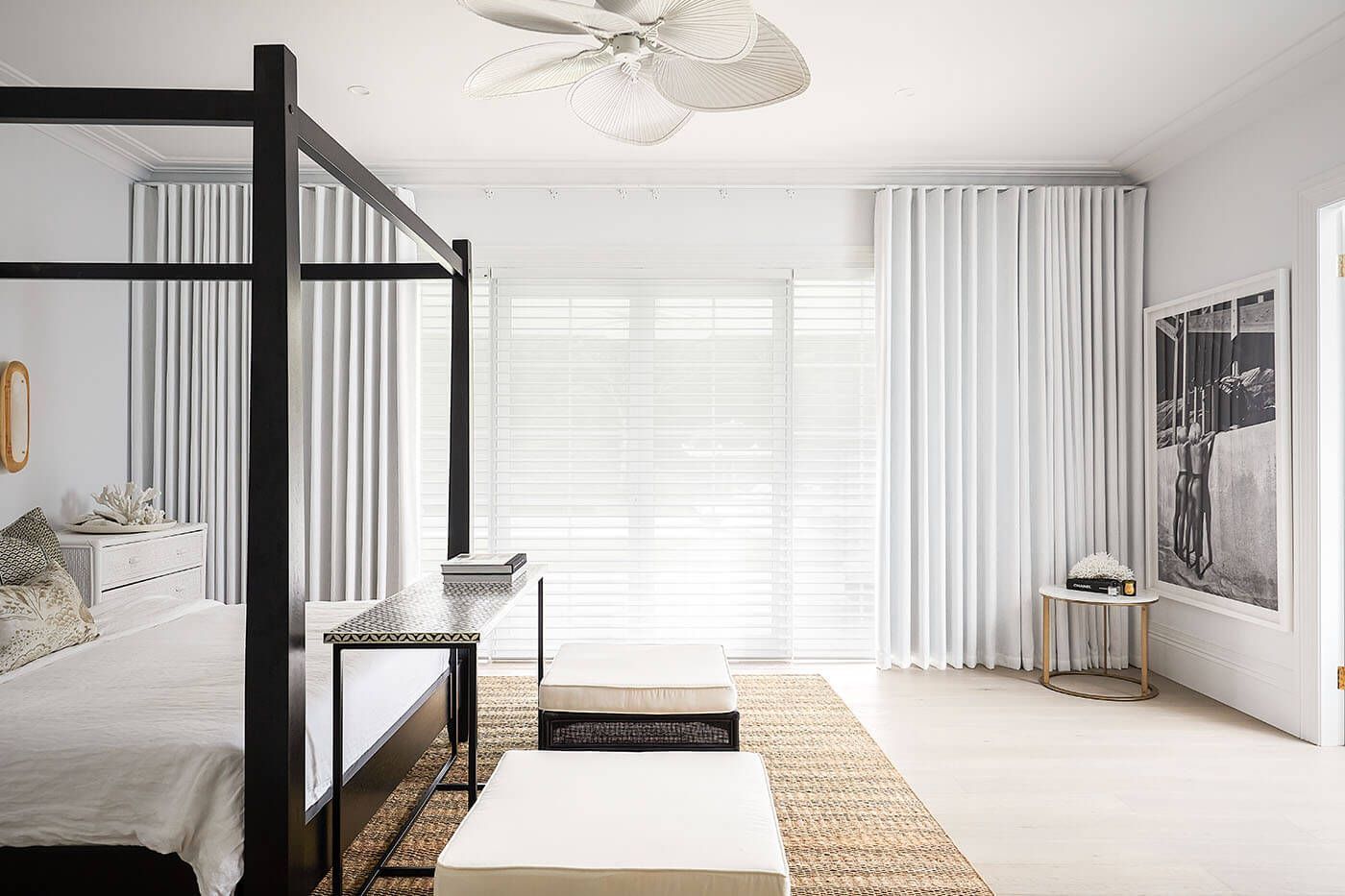 Bedroom with canopy bed, white curtains, neutral rug, and artwork — BlindDESIGN in Byron Bay, NSW