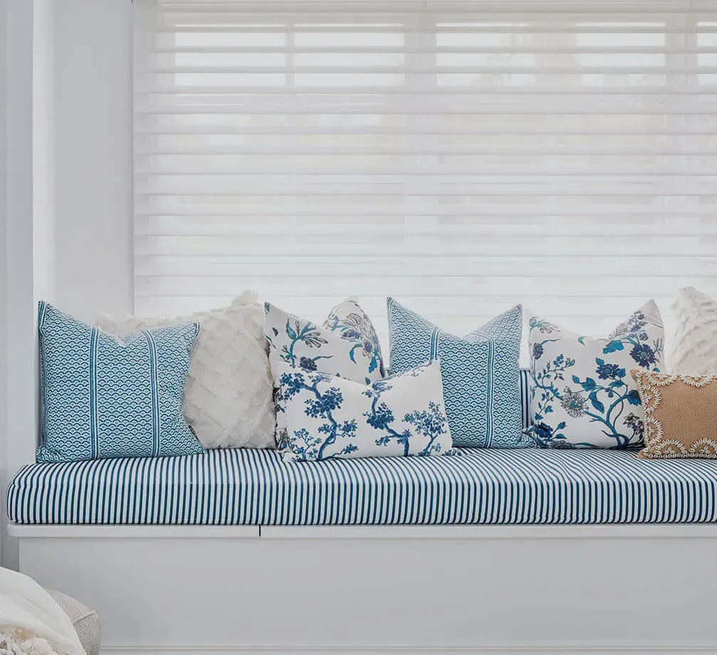 Window Seat With Blue Striped Cushion and Decorative Pillows in Shades of Blue and Cream — BlindDESIGN in Ballina, NSW