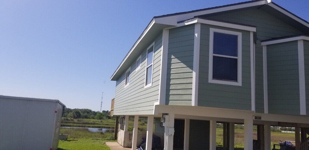 A house with a lot of windows and a blue sky in the background.