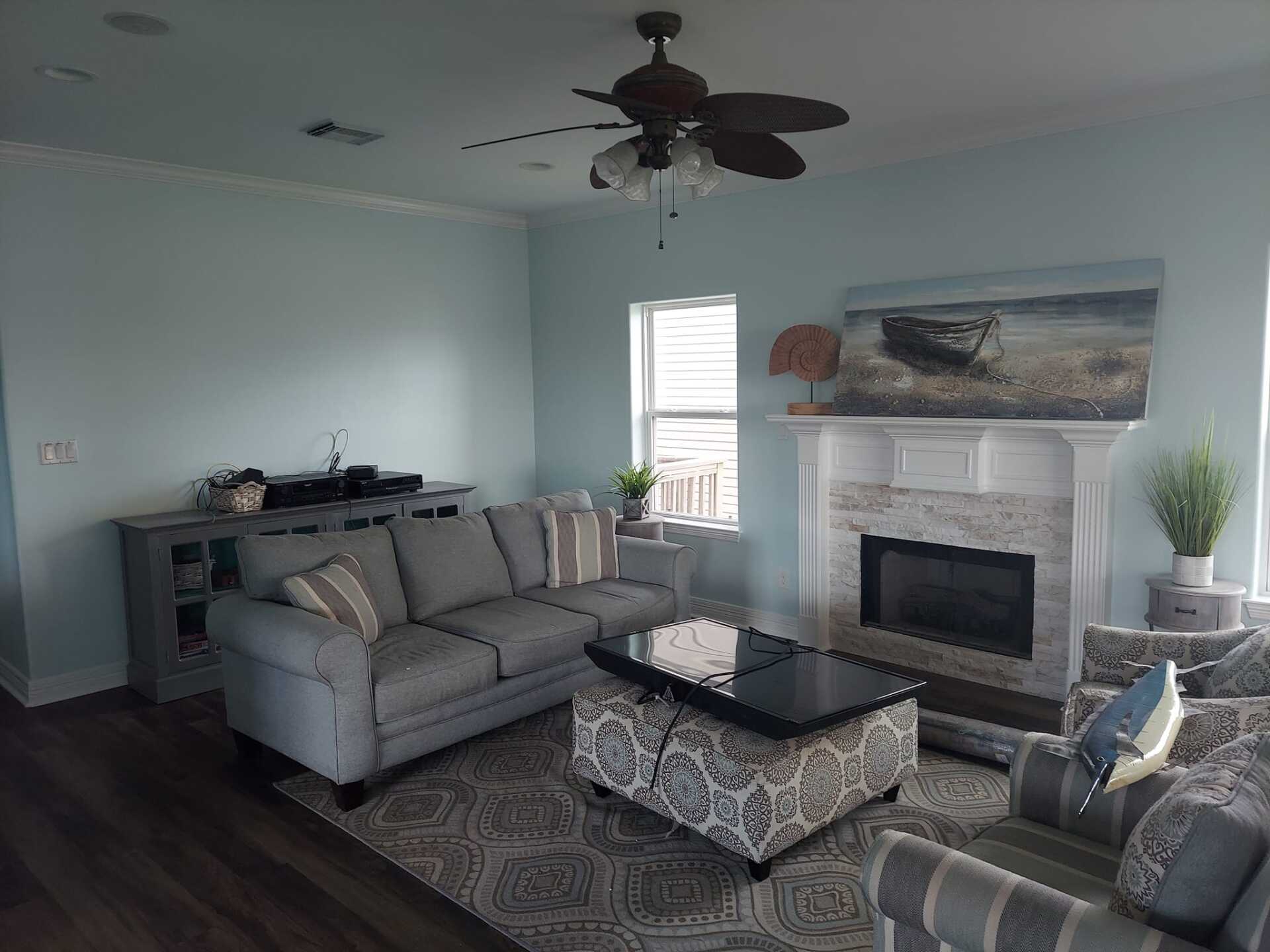 A living room with a couch , chairs , coffee table and fireplace.