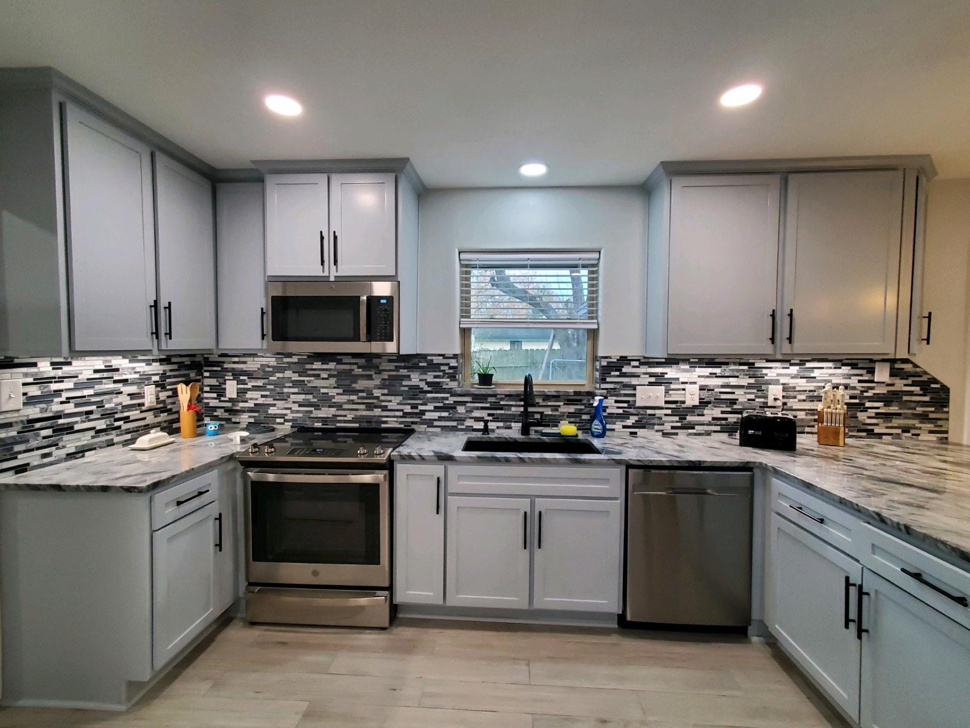 A kitchen with white cabinets and stainless steel appliances
