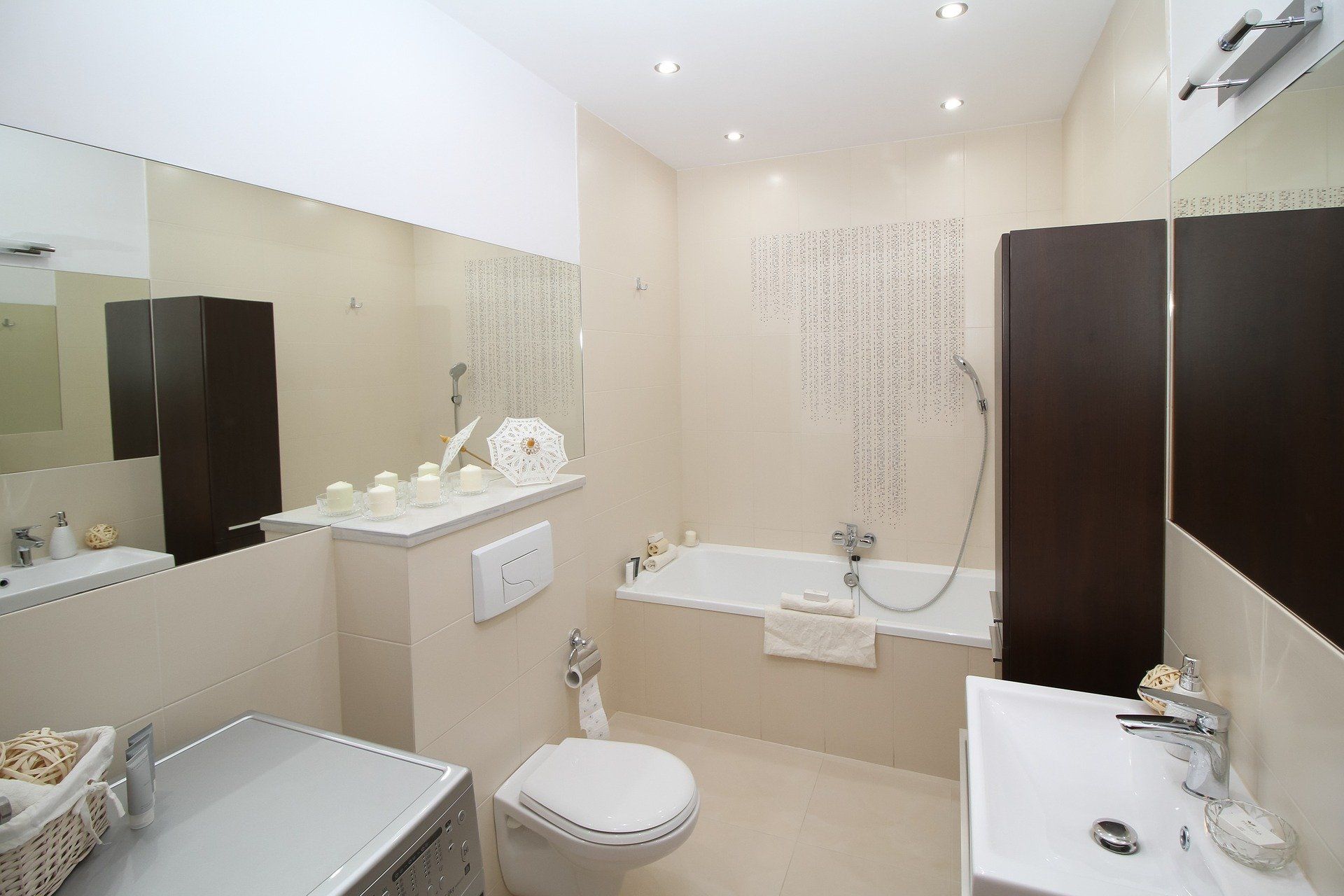 A bathroom with a toilet , sink , bathtub and mirror.