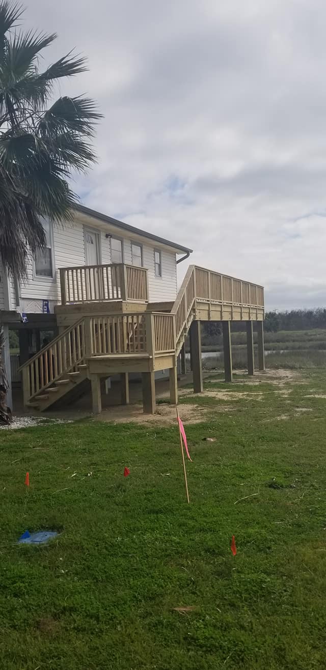 A large wooden deck is being built in front of a house.