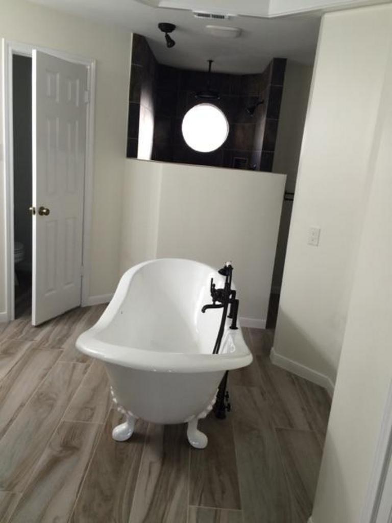 A bathtub is sitting in a bathroom next to a door.