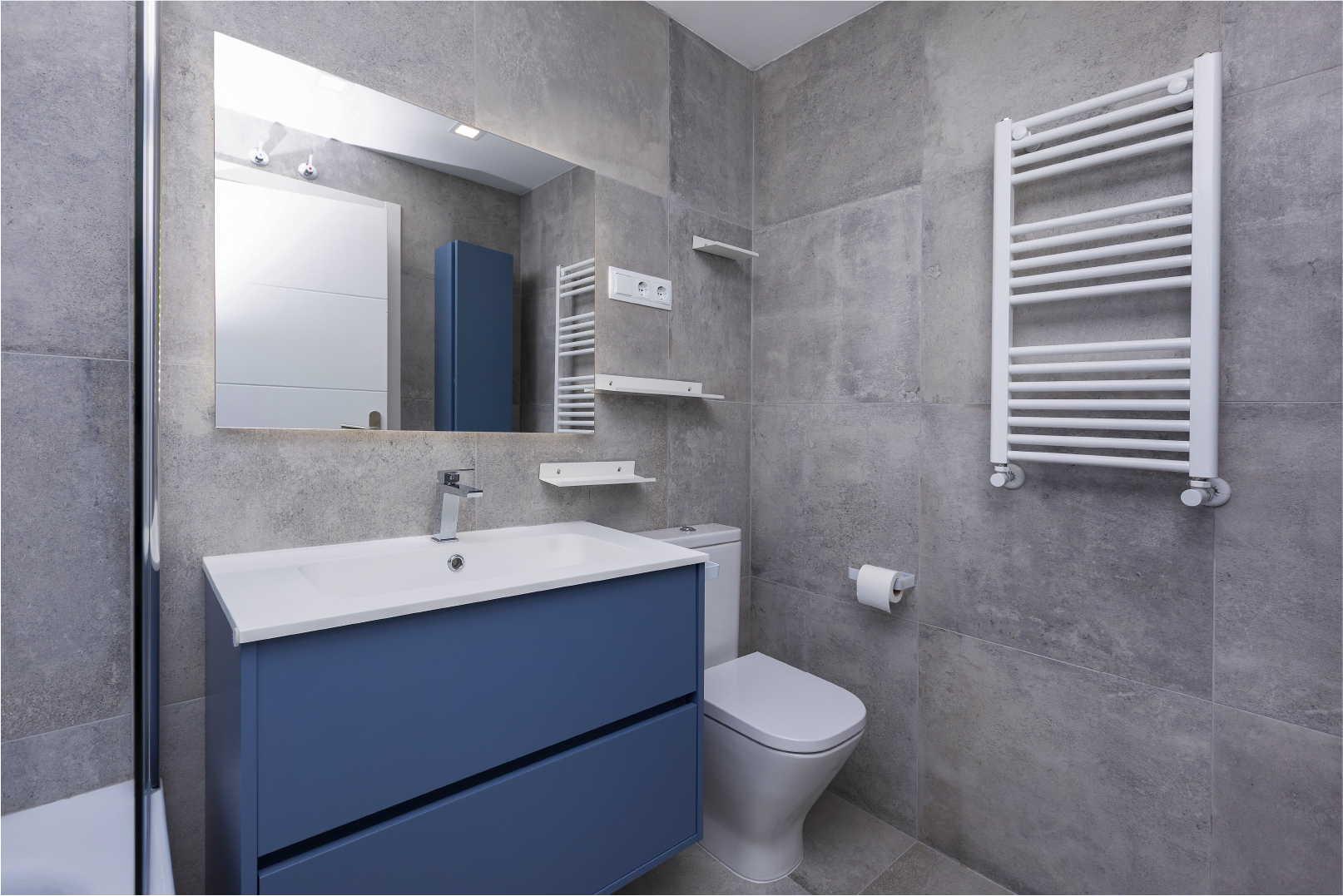 Un cuarto de baño con sanitario, lavabo, espejo y toallero.