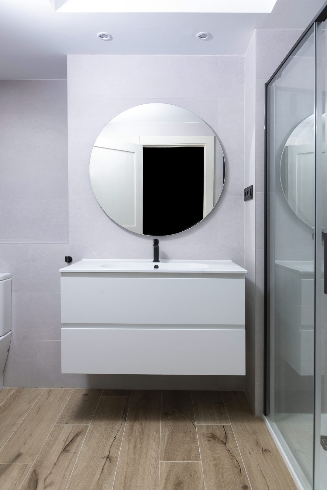 Un baño con lavabo, espejo y ducha.