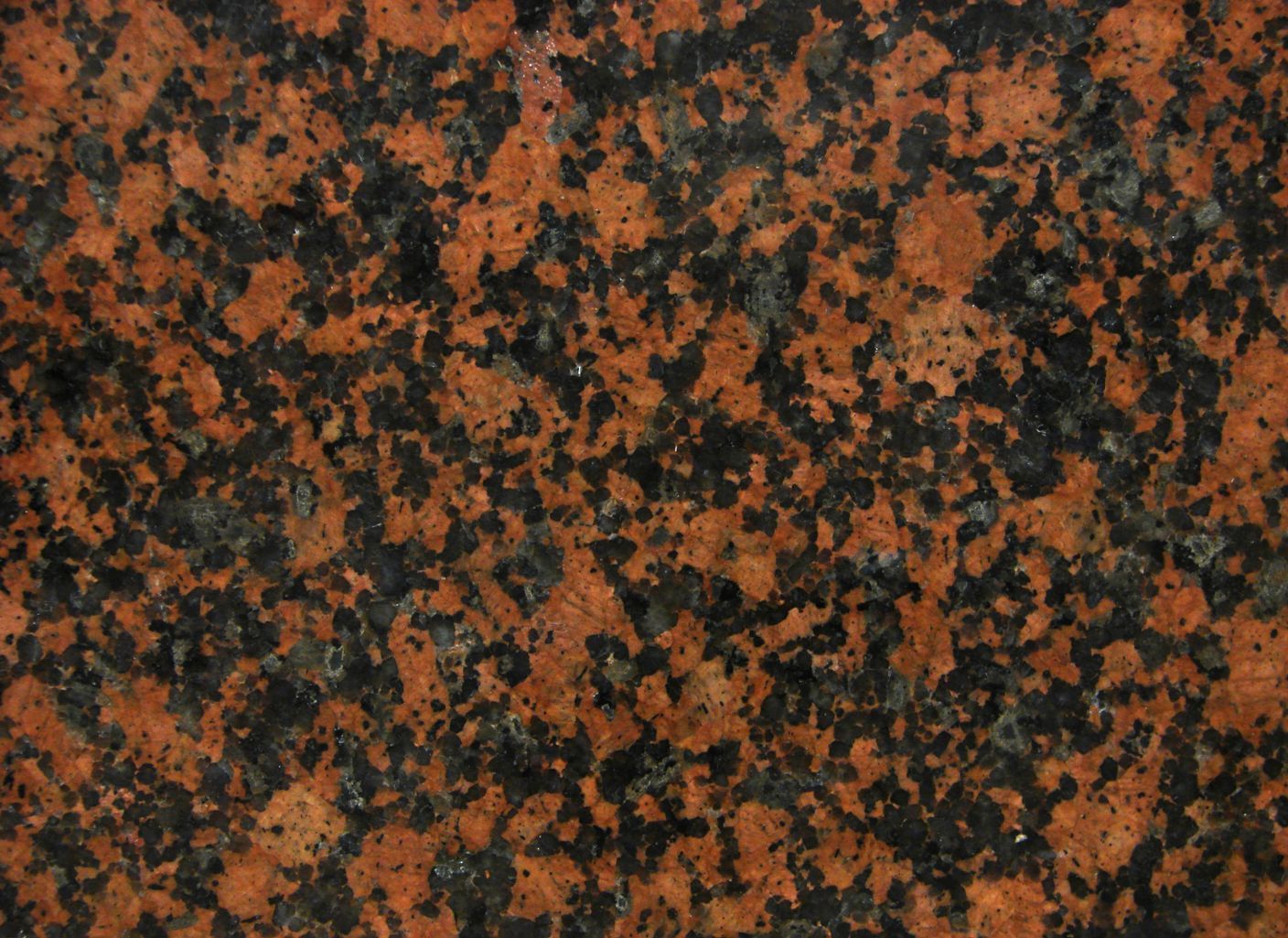 Un primer plano de una superficie de granito rojo y negro.