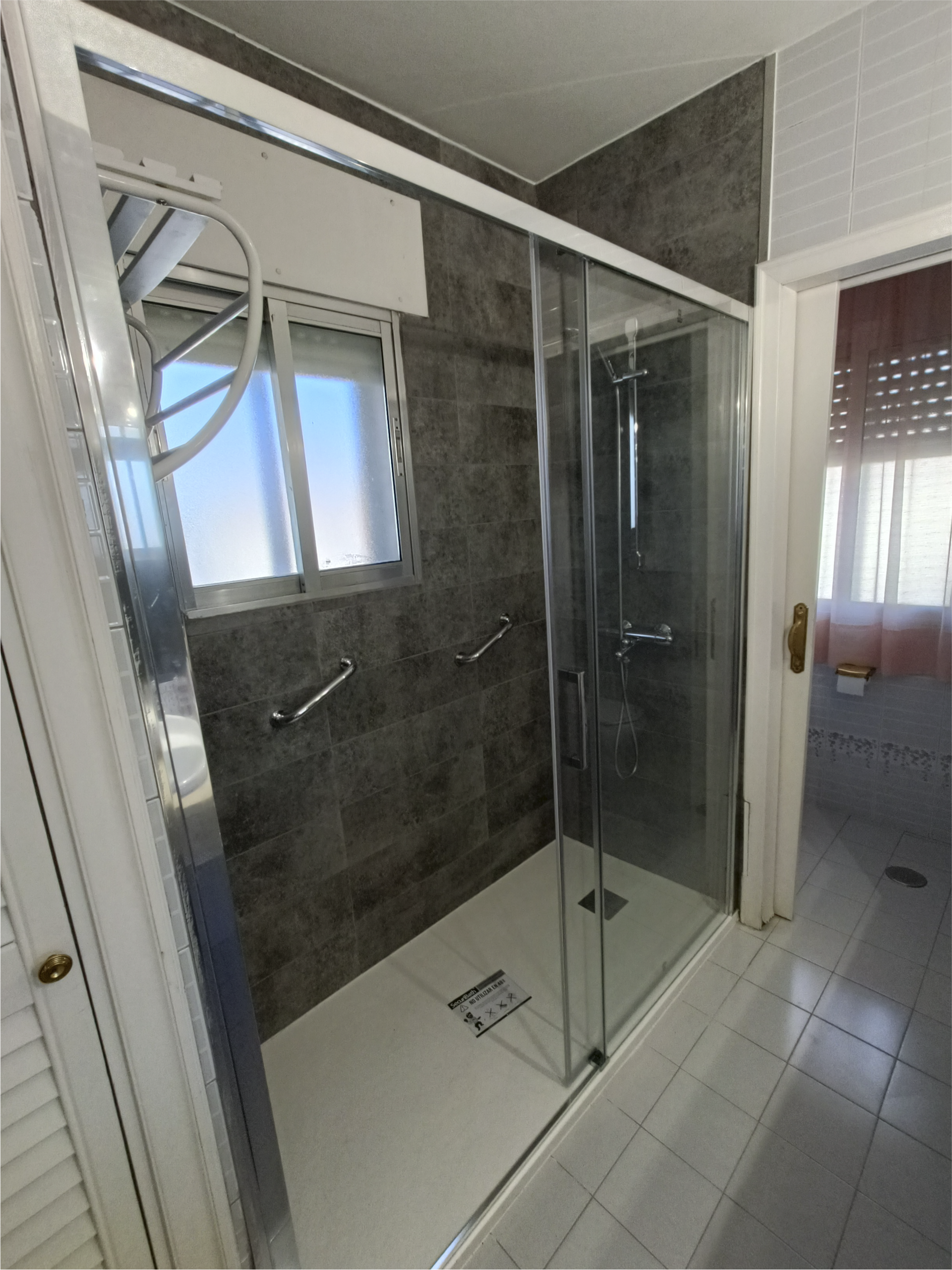 Un baño con plato de ducha y ventana.