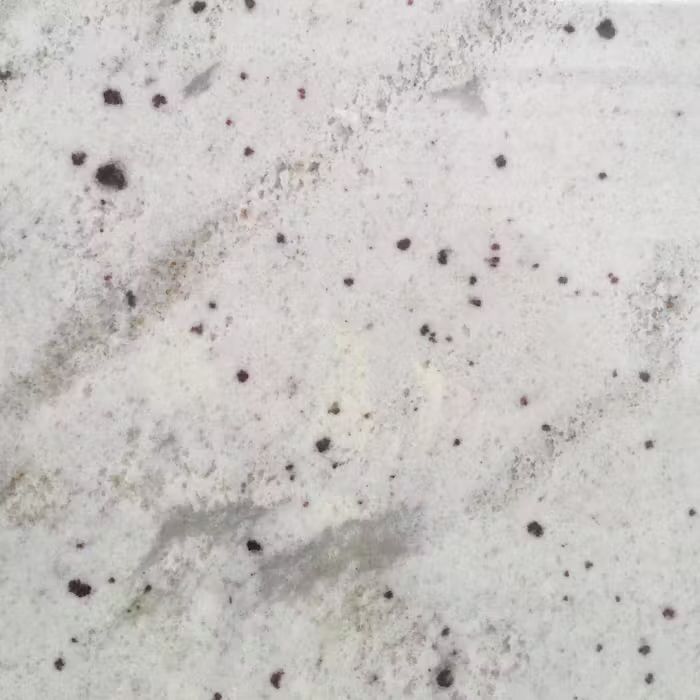 Un primer plano de un azulejo blanco con manchas negras.