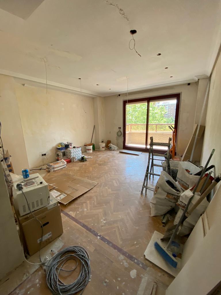 Una habitación grande con muchas cajas y herramientas en el suelo.
