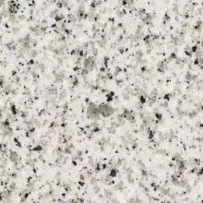 Un primer plano de una encimera de granito blanco con manchas negras.