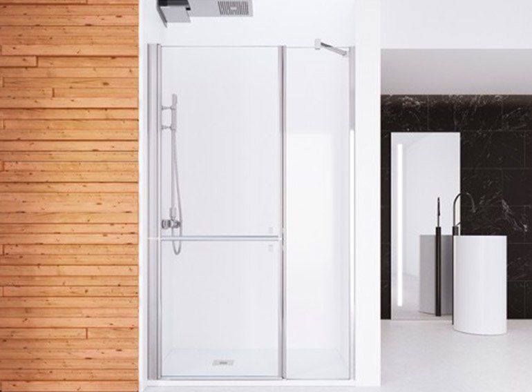 Un baño con puerta corredera de cristal en la ducha y pared de madera.
