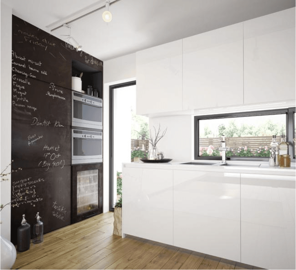 Una cocina con gabinetes blancos y una pared de pizarra.