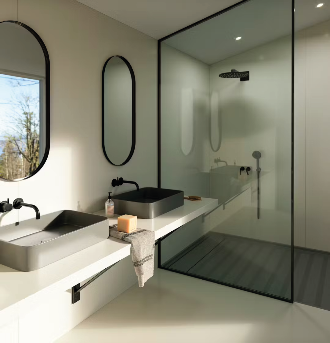 Un baño con lavabo, espejo y plato de ducha.