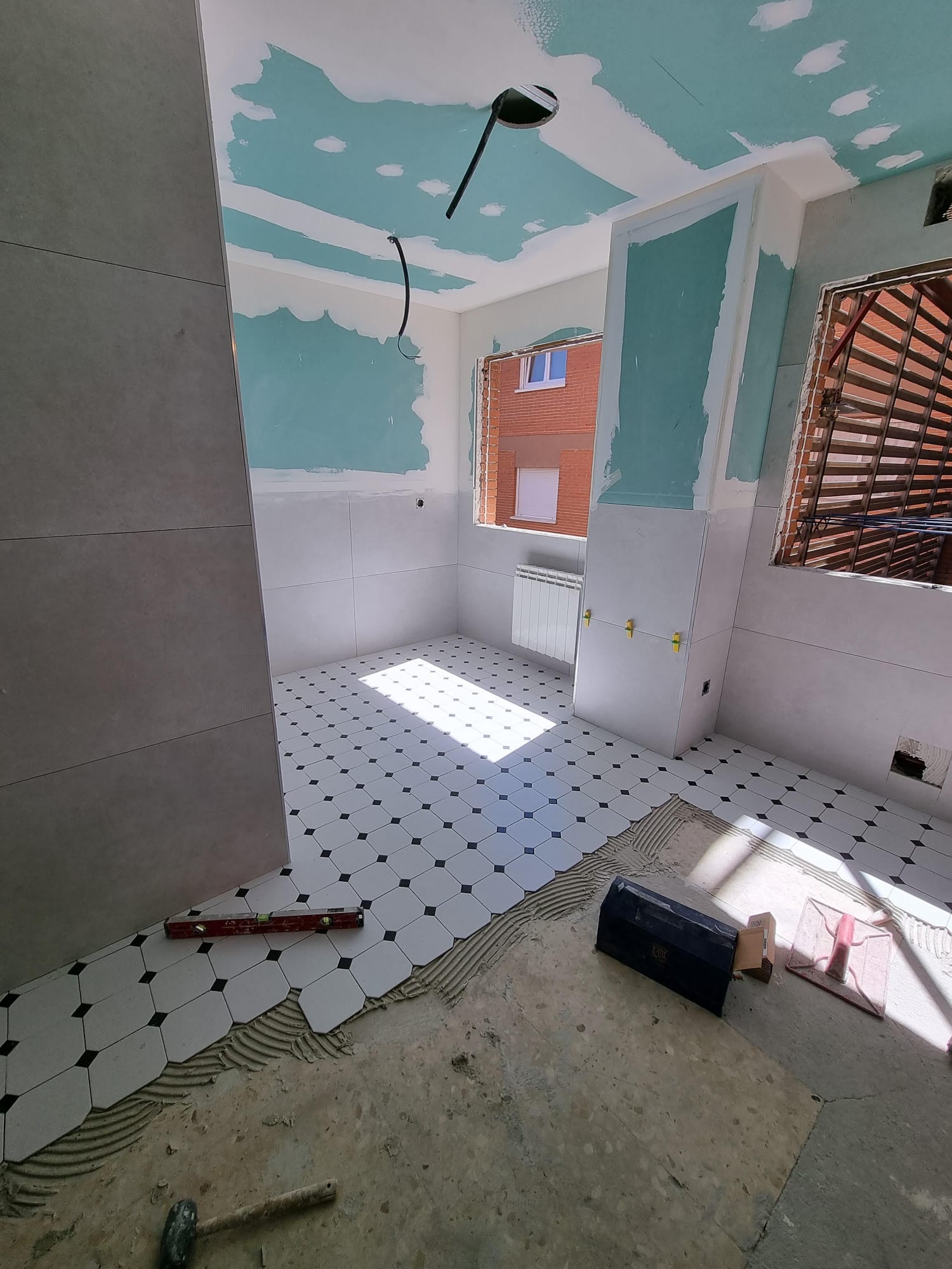 Una habitación con un martillo y un nivel en el suelo.