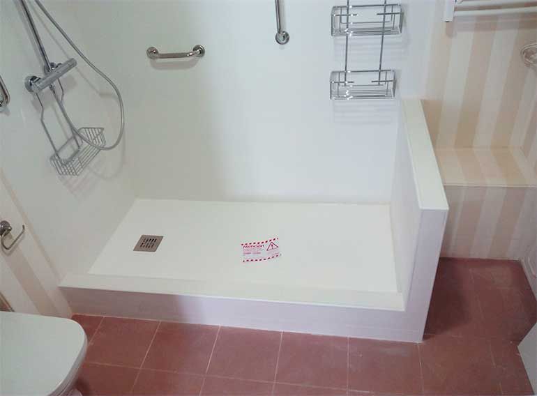 Un cuarto de baño con plato de ducha y aseo.