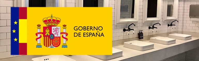 Un baño con un cartel amarillo que dice gobierno de españa.