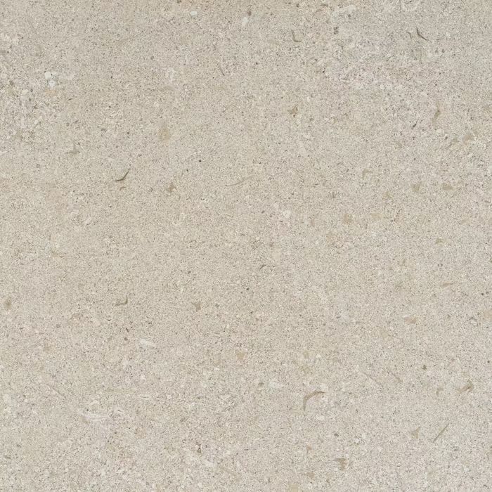 Un primer plano de un azulejo beige con textura granulada.