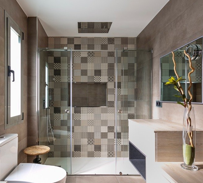 Un baño con mampara de ducha corredera de cristal