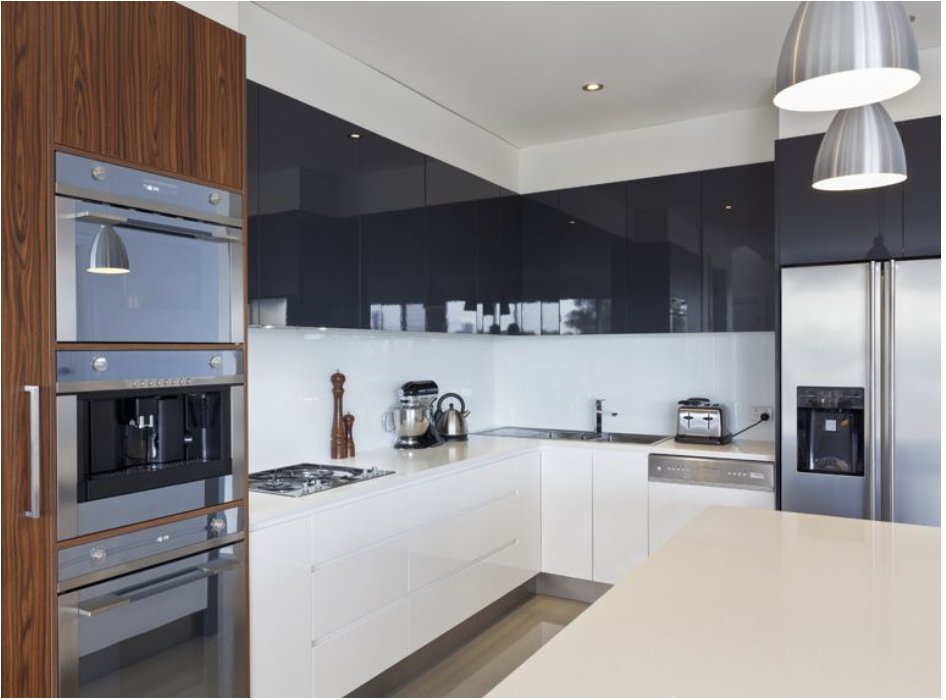 Una cocina con gabinetes blancos y electrodomésticos de acero inoxidable.