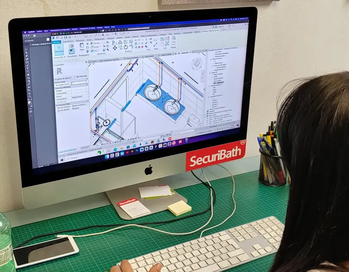 Una mujer está sentada en un escritorio usando una computadora.