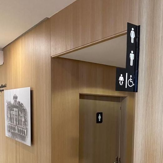 Un baño con un cartel en la pared que dice baños de hombres y mujeres.
