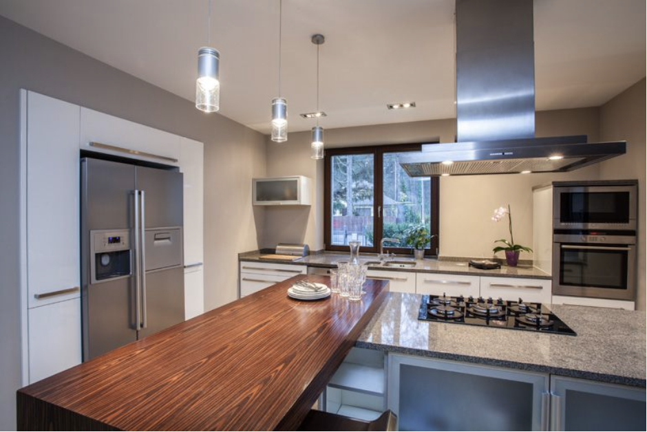 Una cocina con electrodomésticos de acero inoxidable y encimera de madera.