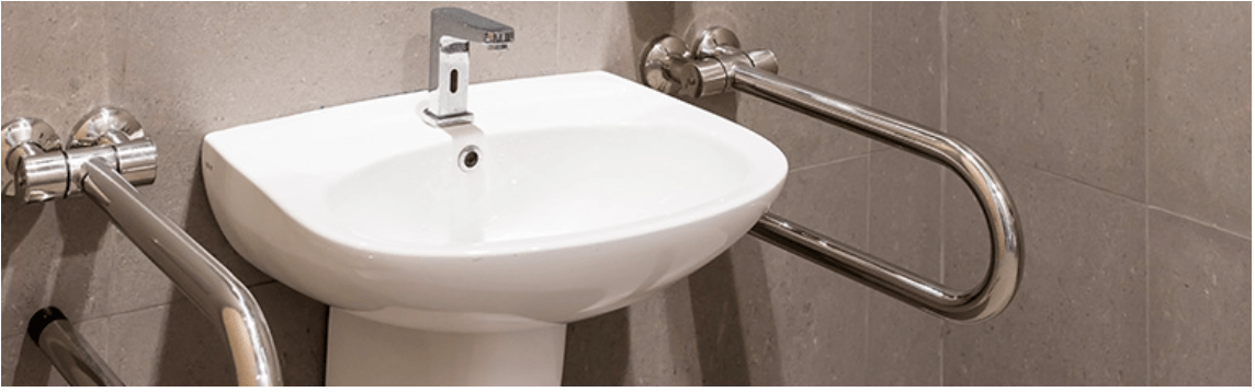 Un lavabo de baño con barandilla de acero inoxidable adosada.