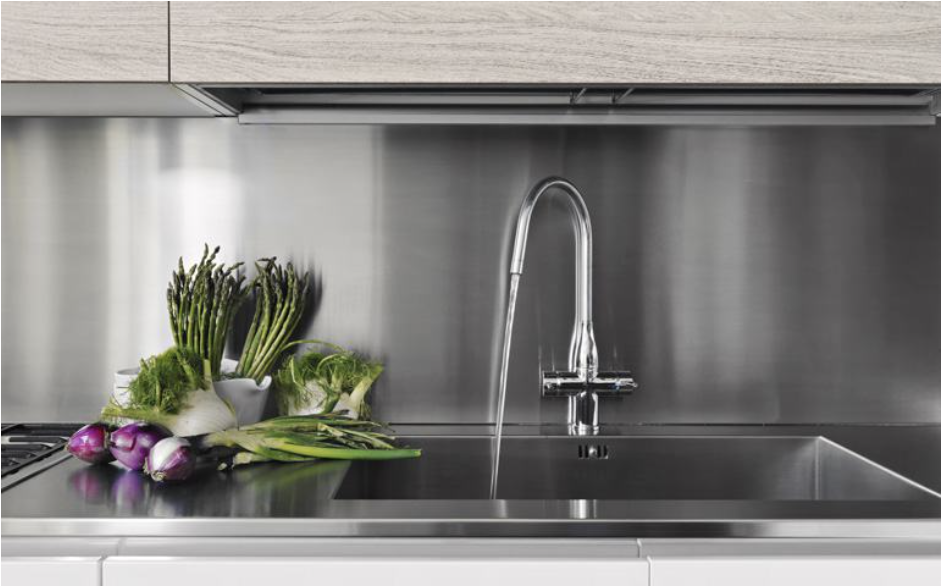 Un fregadero de acero inoxidable con verduras en el mostrador