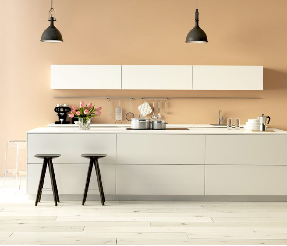 Una cocina con armarios y taburetes blancos y un jarrón de flores sobre la encimera.